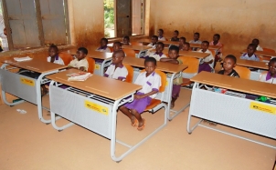 Pupils using new desk in their classroom